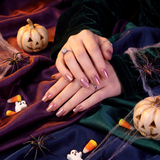 Woman wearing Aurora Pink press-on nails with a soft Halloween-inspired beauty look.